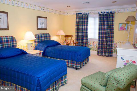 carpeted bedroom with visible vents and crown molding