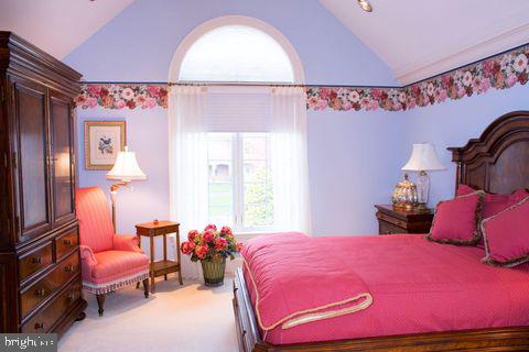 bedroom with vaulted ceiling and carpet floors