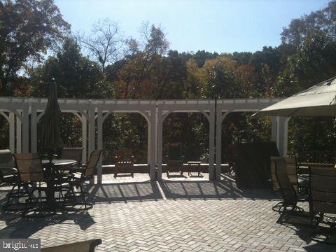 view of home's community with outdoor dining space, a patio, and a pergola