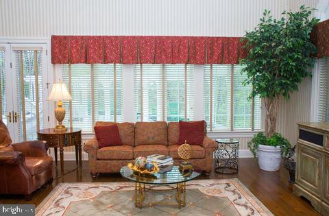 living room with wood finished floors and wallpapered walls