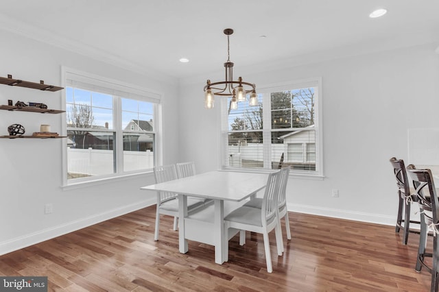 dining room featuring ornamental molding, an inviting chandelier, baseboards, and wood finished floors