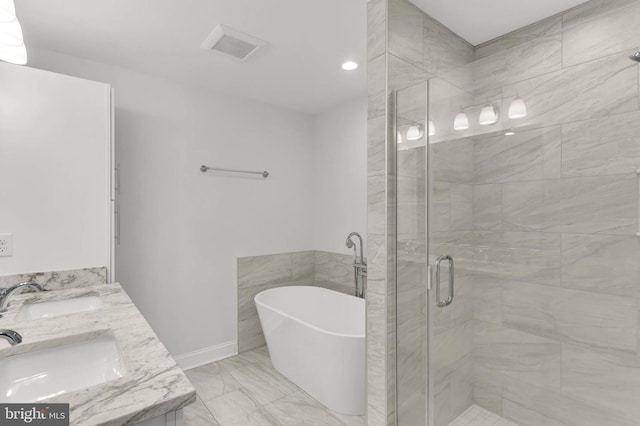 bathroom with a freestanding tub, a shower stall, marble finish floor, and a sink