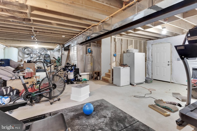 unfinished basement featuring stairs, water heater, and freestanding refrigerator