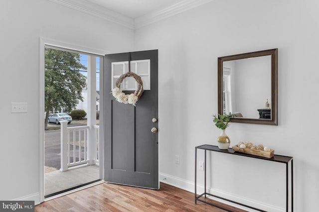 entryway with baseboards, ornamental molding, and wood finished floors