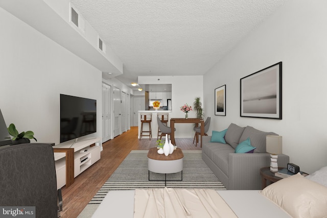 living area featuring wood finished floors and a textured ceiling