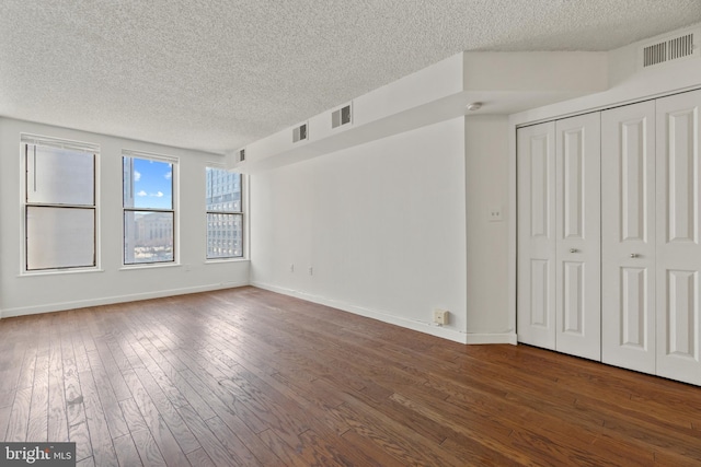 unfurnished bedroom with dark wood finished floors, visible vents, and baseboards