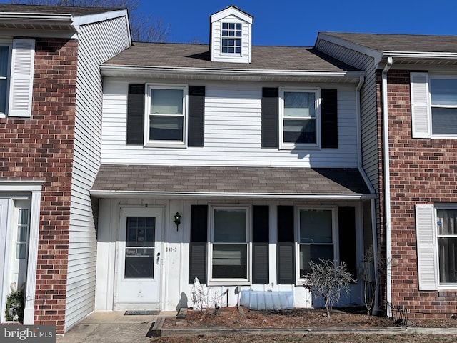 multi unit property with brick siding and roof with shingles