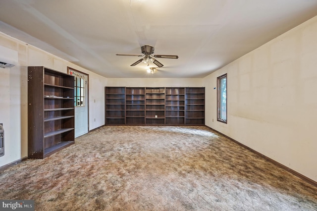 spare room featuring baseboards, a ceiling fan, carpet flooring, and an AC wall unit