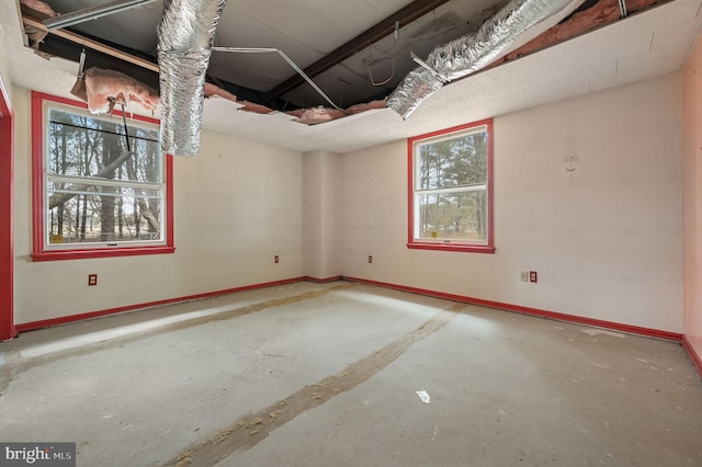 unfurnished room featuring unfinished concrete flooring and baseboards