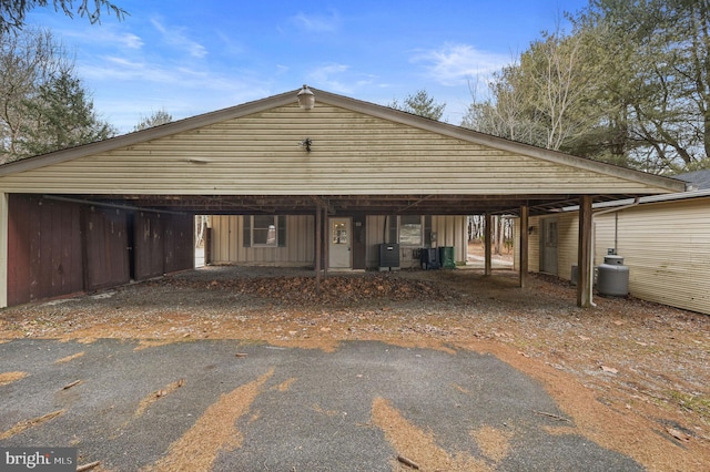 view of front of home with central AC, a carport, and board and batten siding