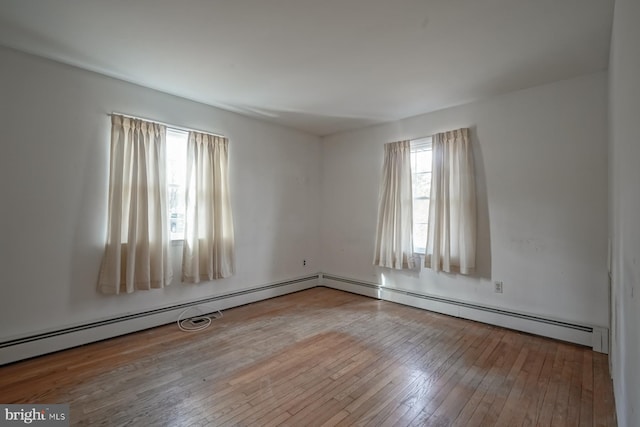 unfurnished room with hardwood / wood-style flooring and a baseboard radiator