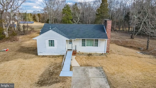 view of front of home featuring a shingled roof and a chimney