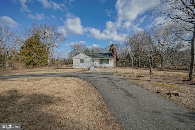 view of front of home with aphalt driveway and a chimney