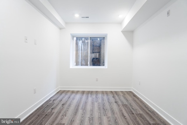 empty room featuring light wood finished floors, baseboards, and visible vents