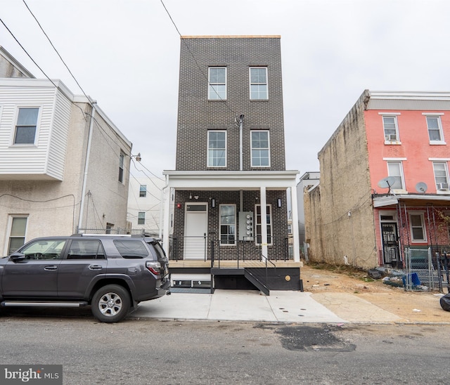 multi unit property with a porch and brick siding