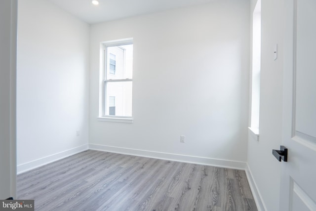 empty room with light wood-style floors, recessed lighting, and baseboards