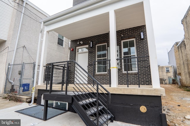 doorway to property featuring brick siding