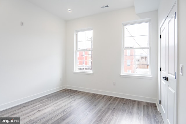 spare room with light wood finished floors, visible vents, baseboards, and recessed lighting