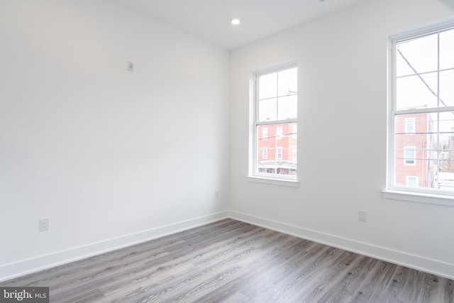 unfurnished room with light wood-type flooring, baseboards, and recessed lighting