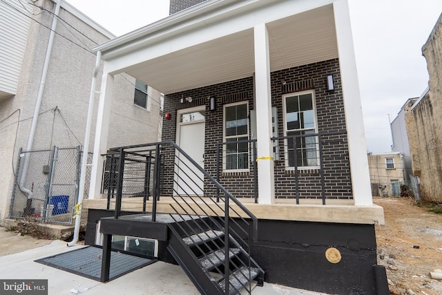 view of exterior entry featuring brick siding