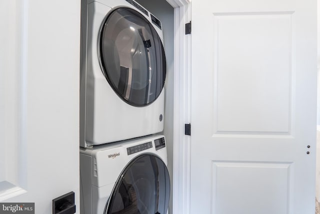 clothes washing area featuring stacked washer / drying machine and laundry area