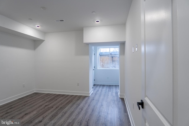 unfurnished room featuring dark wood finished floors, visible vents, and baseboards