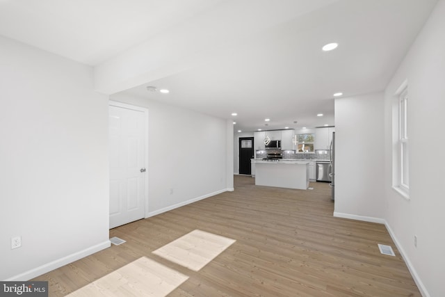 unfurnished living room with baseboards, light wood-style flooring, and recessed lighting