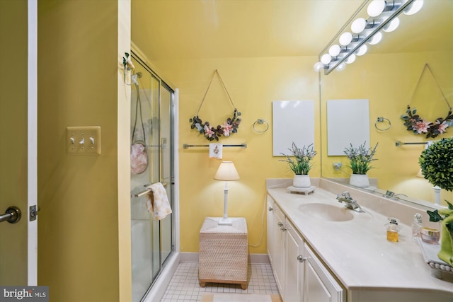 full bath featuring tile patterned floors, baseboards, a shower stall, and vanity