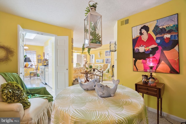 dining room featuring baseboards, visible vents, carpet floors, and a textured ceiling