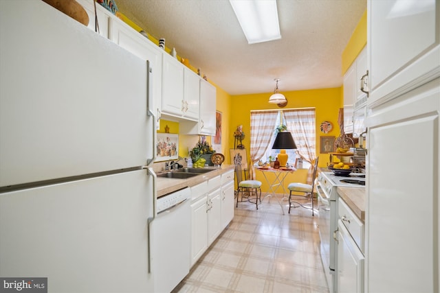 kitchen with light floors, white appliances, white cabinetry, and light countertops