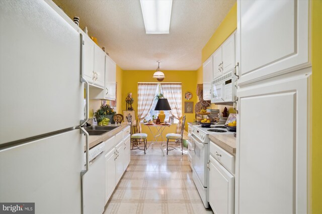 kitchen featuring white appliances, light floors, and white cabinets