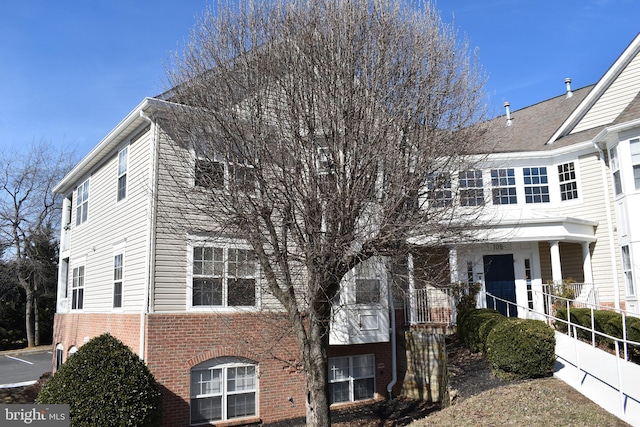 townhome / multi-family property featuring brick siding and fence