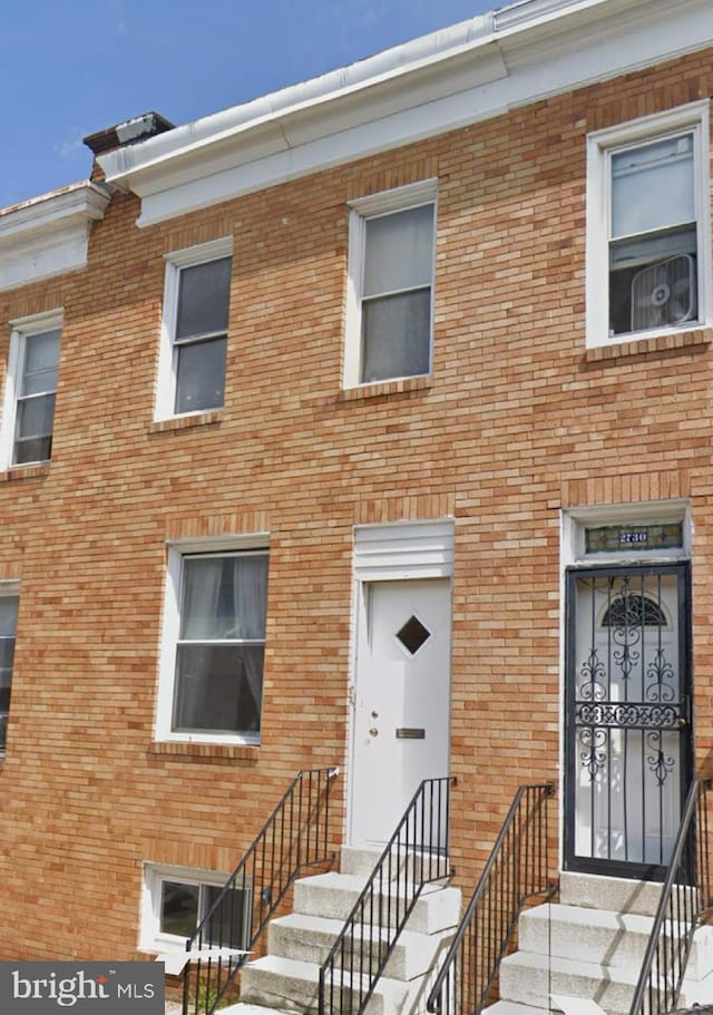 townhome / multi-family property featuring entry steps and brick siding