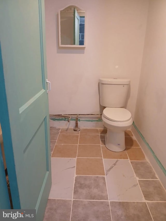 bathroom featuring toilet, baseboards, and tile patterned floors