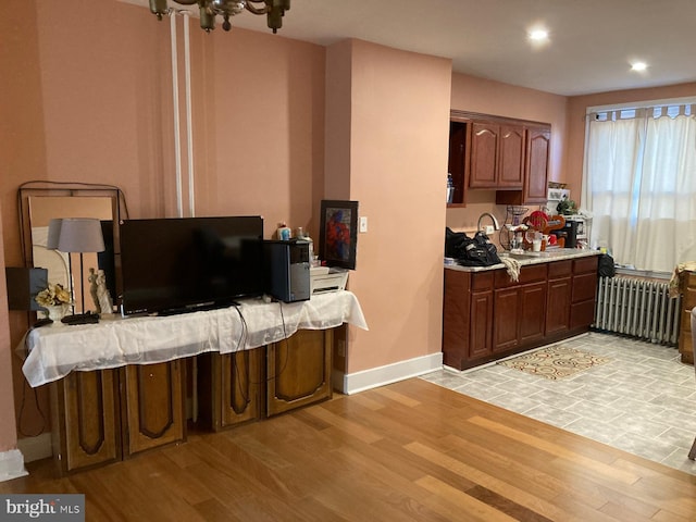 kitchen featuring recessed lighting, baseboards, light wood-style floors, light countertops, and radiator