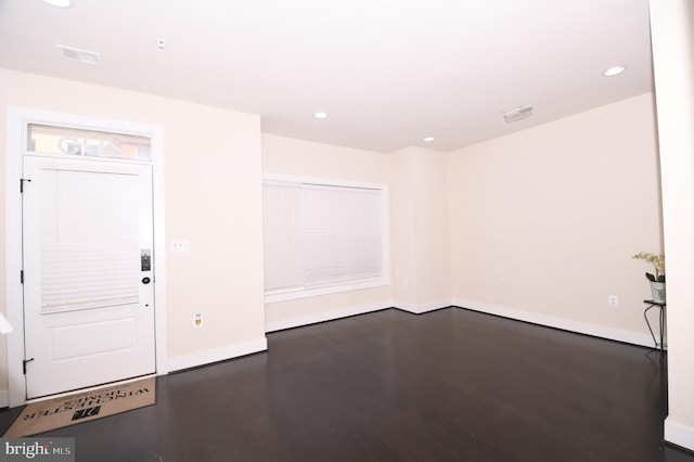 unfurnished room with dark wood-style floors, baseboards, visible vents, and recessed lighting