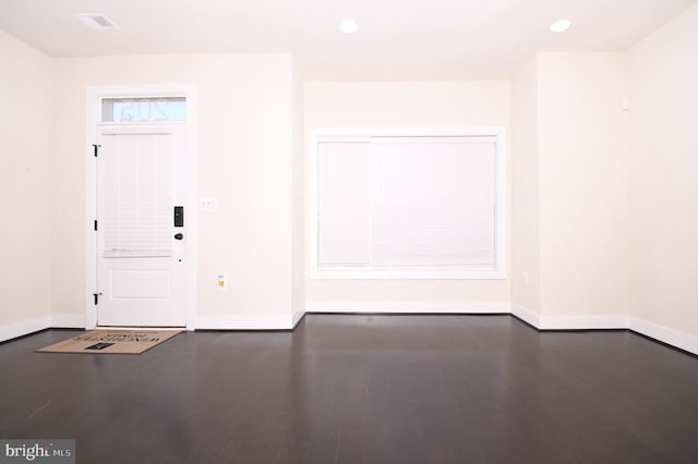 foyer entrance with visible vents, baseboards, dark wood-type flooring, and recessed lighting