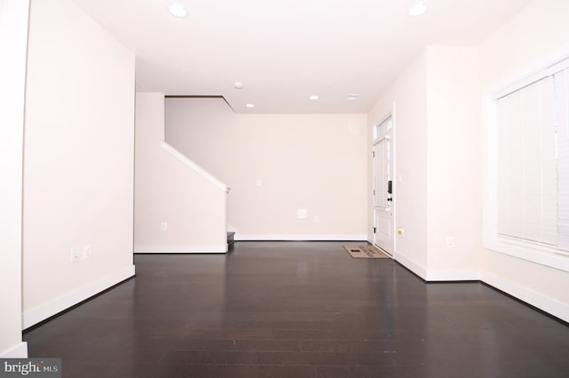 spare room with recessed lighting, dark wood-style flooring, and baseboards