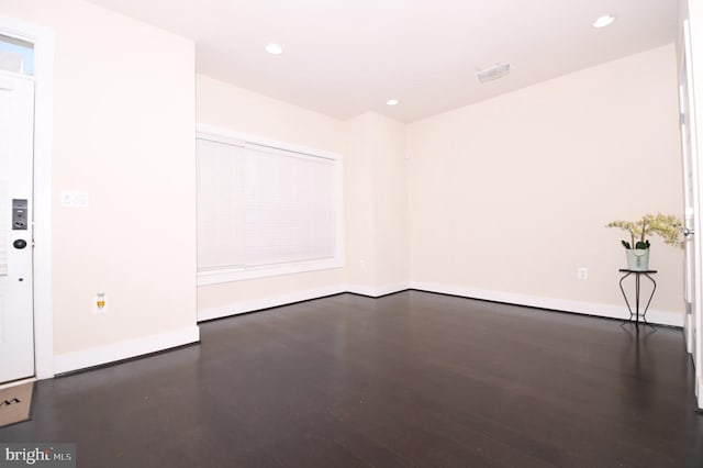 spare room with dark wood-type flooring, recessed lighting, and baseboards