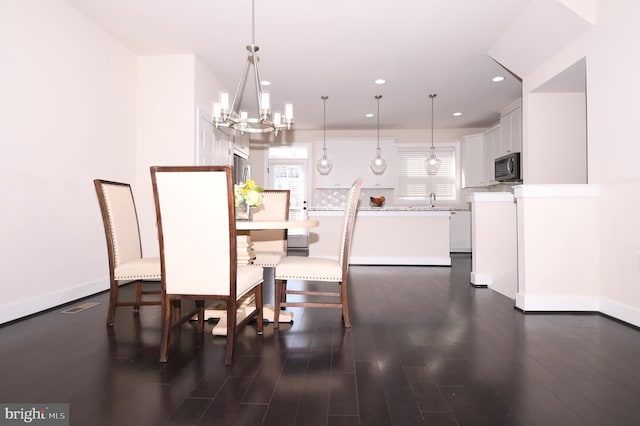 dining area featuring dark wood-style floors, recessed lighting, a wealth of natural light, and an inviting chandelier