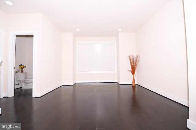 unfurnished room with baseboards, dark wood finished floors, and recessed lighting