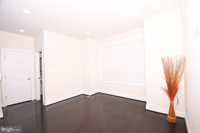 empty room with baseboards, dark wood-style flooring, and recessed lighting