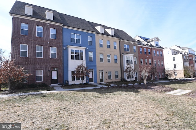 exterior space featuring brick siding and a front yard