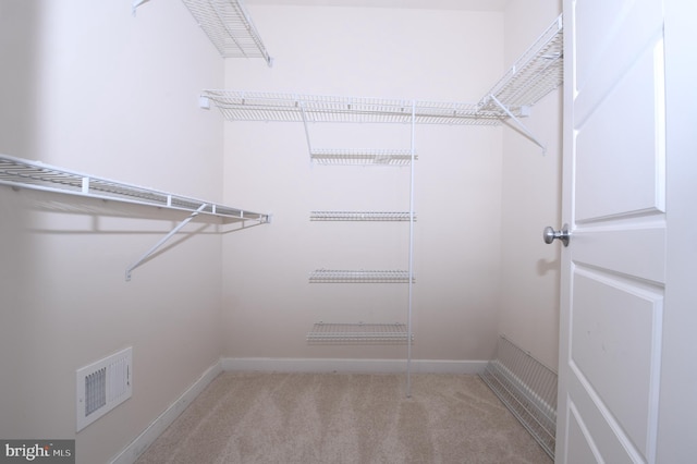 spacious closet with visible vents and light colored carpet