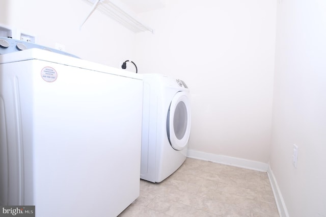 washroom with laundry area, washer / clothes dryer, and baseboards