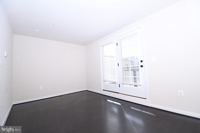 empty room with baseboards and wood finished floors