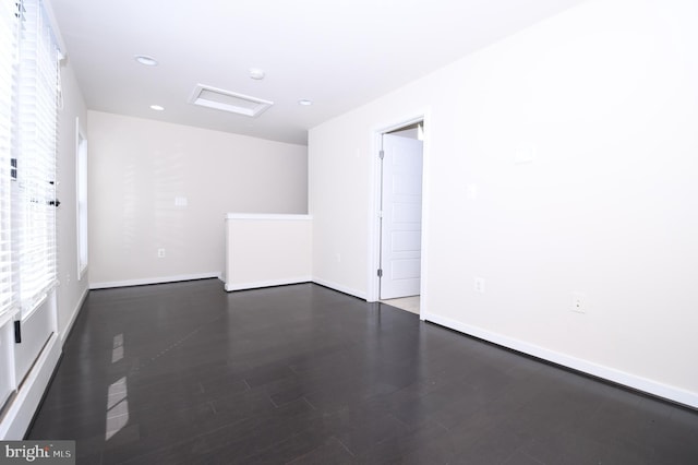 spare room featuring recessed lighting, dark wood finished floors, and baseboards