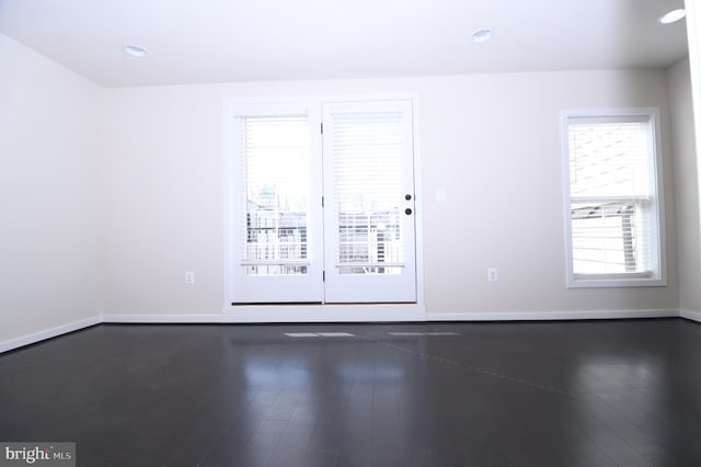 spare room featuring recessed lighting, dark wood finished floors, and baseboards