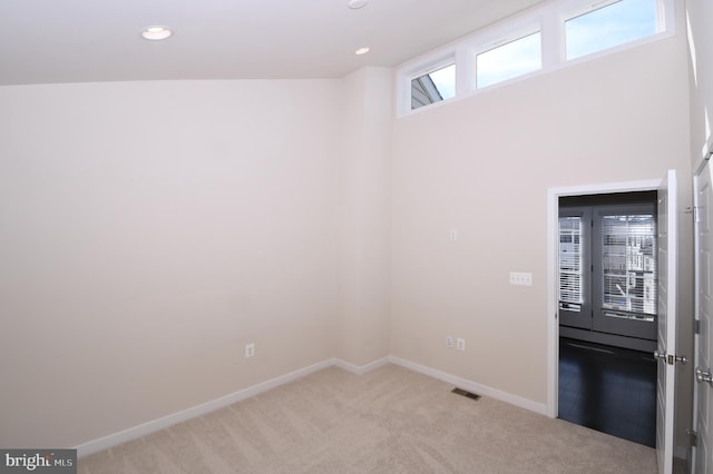 unfurnished room featuring baseboards, recessed lighting, visible vents, and light colored carpet