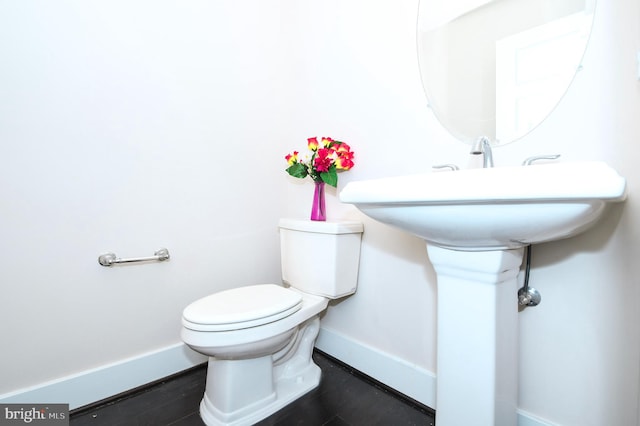 bathroom with toilet and baseboards